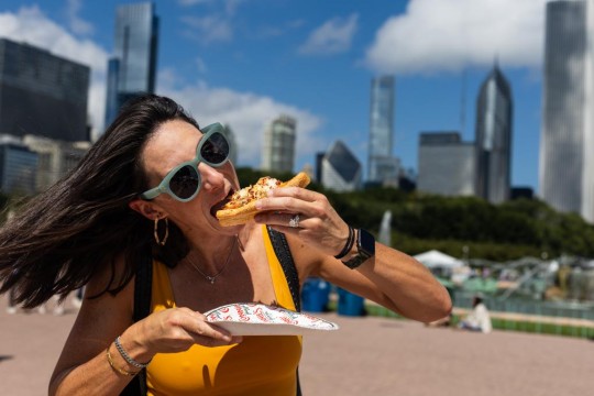 امرأة تأكل قطعة من البيتزا على طريقة شيكاغو