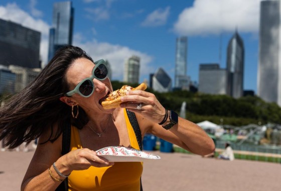 امرأة تأكل قطعة من البيتزا على طريقة شيكاغو
